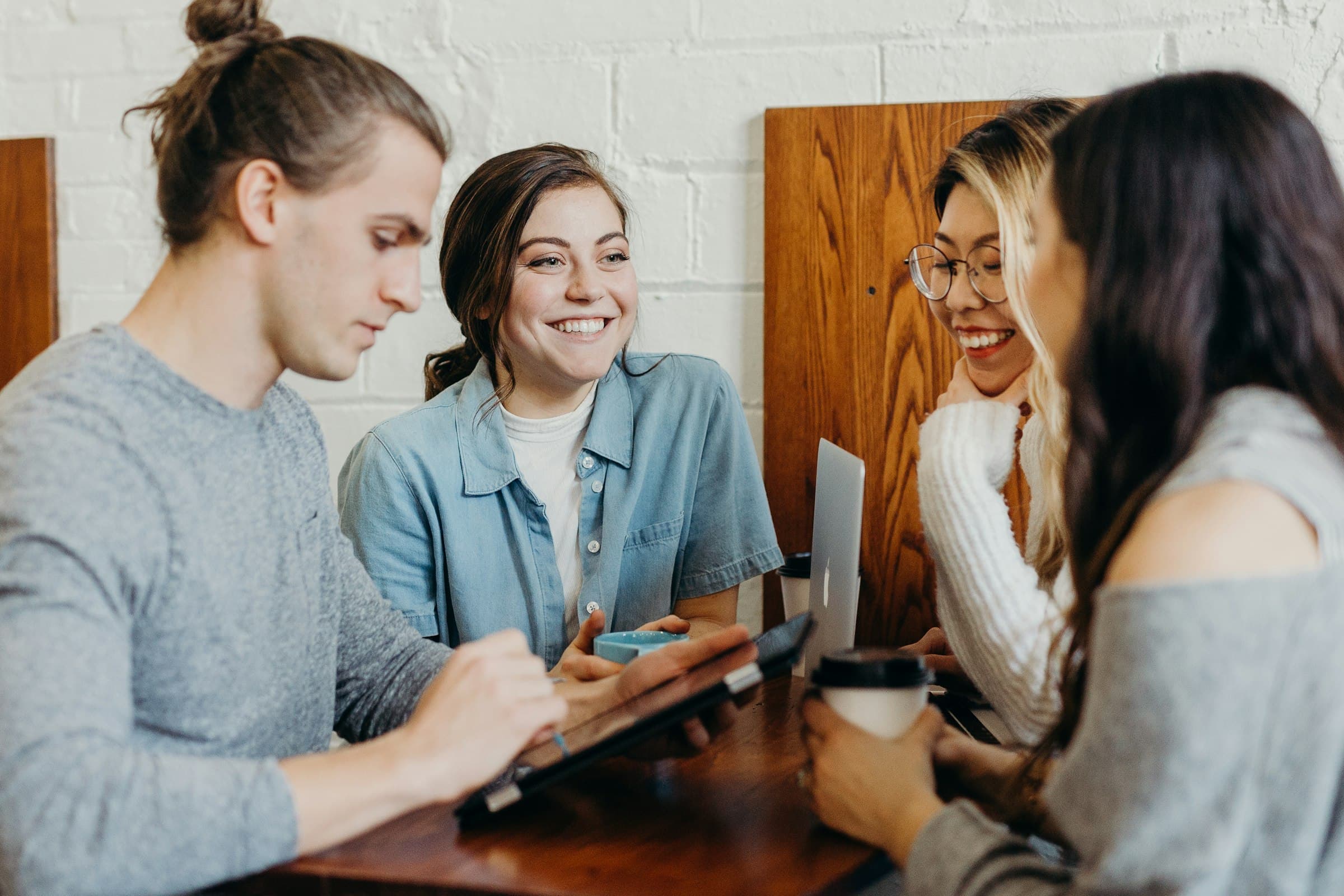 Pessoas em uma mesa usando tablet e notebook